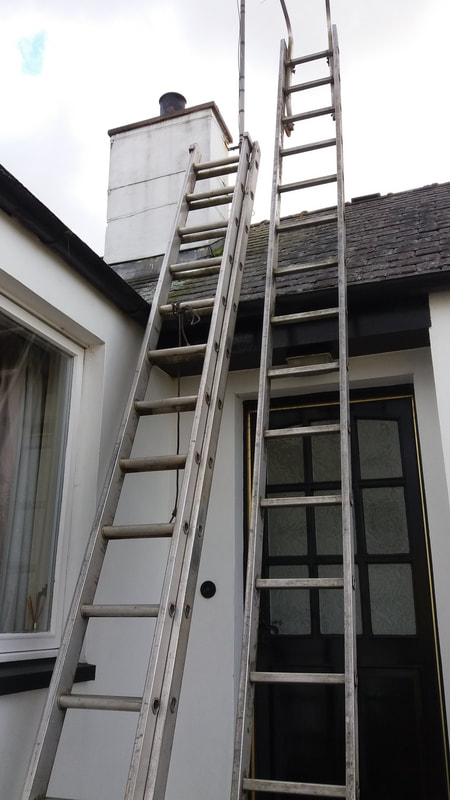 ladders leading up to a chimney pot repair